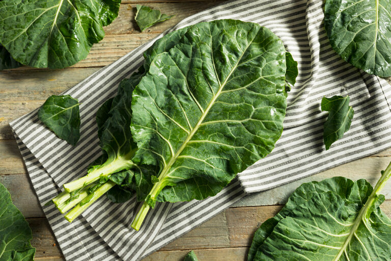 aw collard greens on a striped napkin on a wooden table